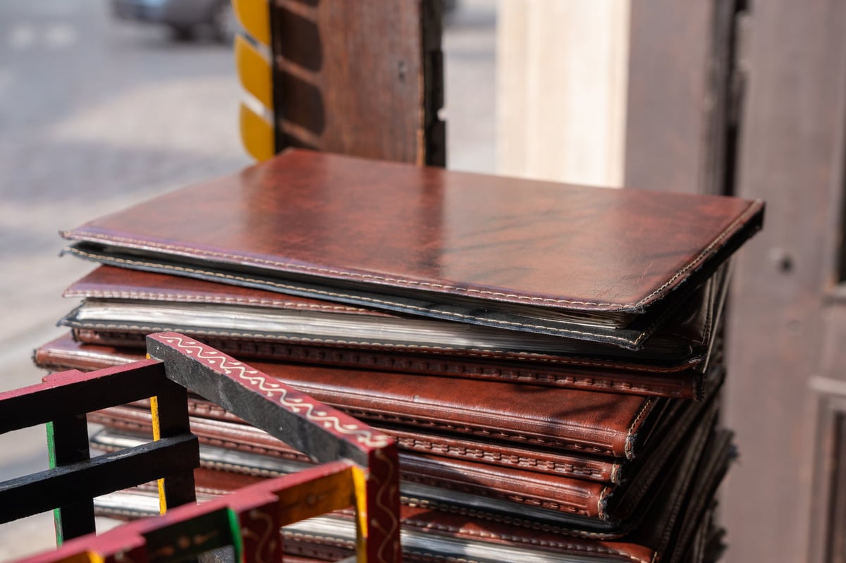 Restaurant paper menus pile, menu books in leather covers stack